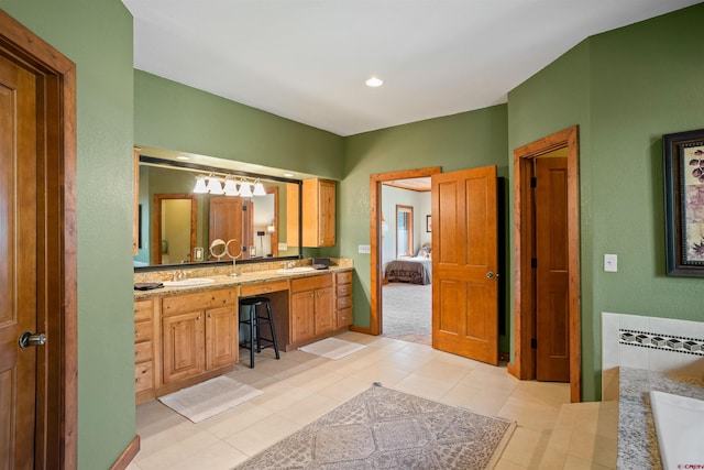 bathroom featuring a bathtub, vanity, and tile patterned floors