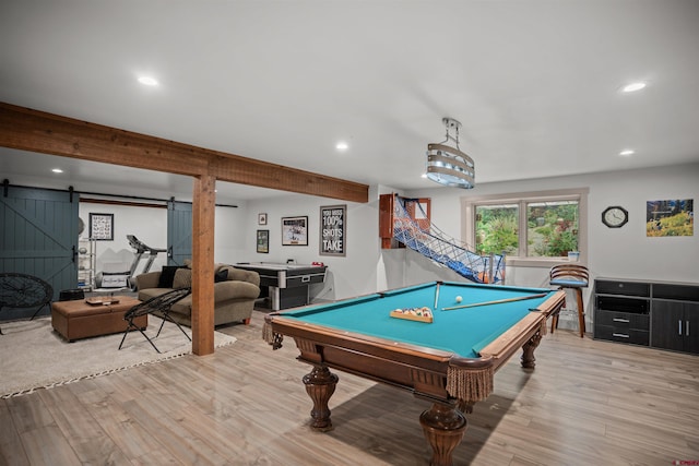 game room featuring a barn door, light hardwood / wood-style floors, and billiards