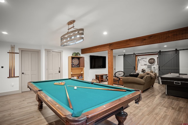 recreation room featuring a barn door, light wood-type flooring, and billiards