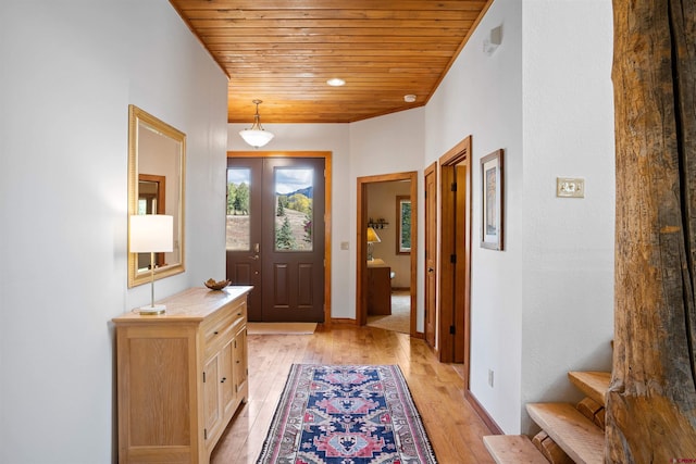 doorway to outside featuring light hardwood / wood-style flooring and wood ceiling