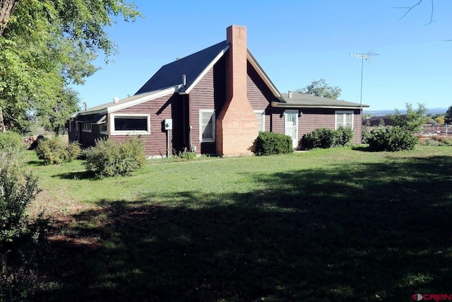 410 E Empire St, Cortez, CO 81321 - view of side of home featuring a chimney and a yard