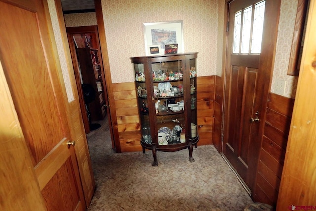 hall with dark carpet and wooden walls