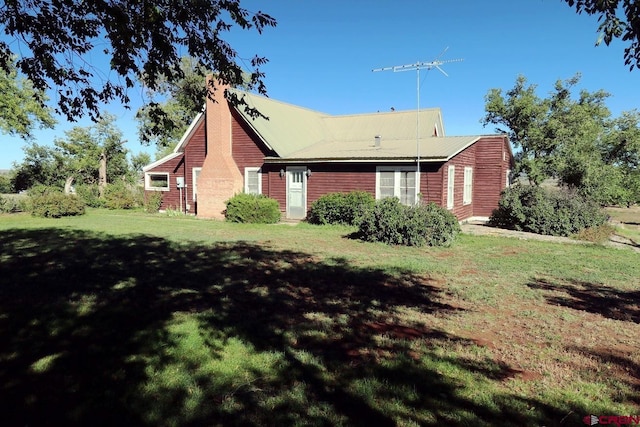 410 E Empire St, Cortez, CO 81321 - view of home's exterior featuring a lawn and a chimney