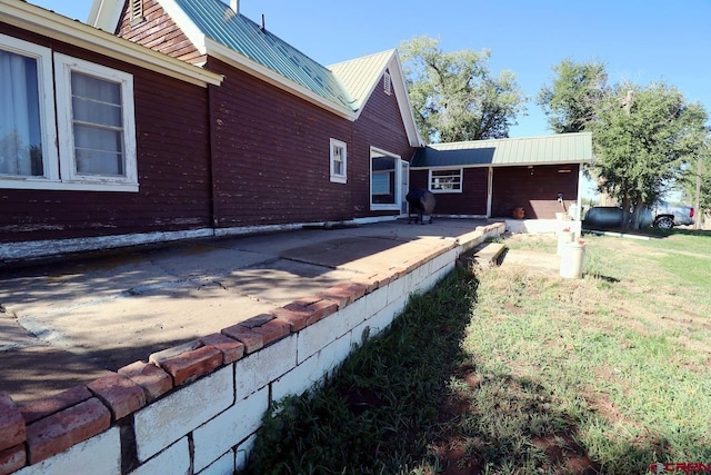 view of home's exterior featuring a lawn and a patio area