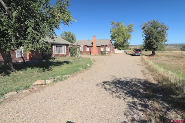 410 E Empire St, Cortez, CO 81321 - view of front of house featuring dirt driveway and a chimney