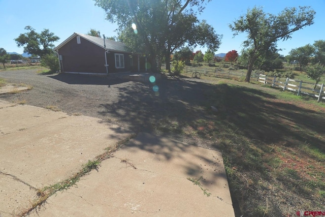 exterior space with a garage and a rural view