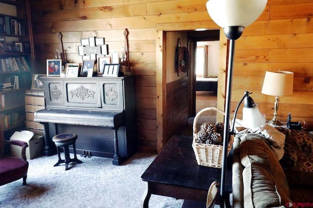 sitting room featuring carpet floors and wood walls