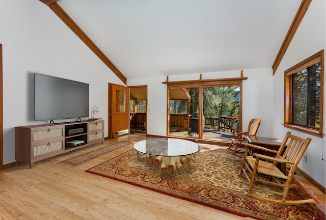 living room with wood finished floors, beamed ceiling, baseboards, and high vaulted ceiling