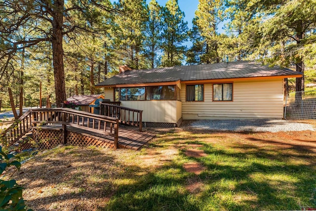 back of property featuring metal roof and a lawn