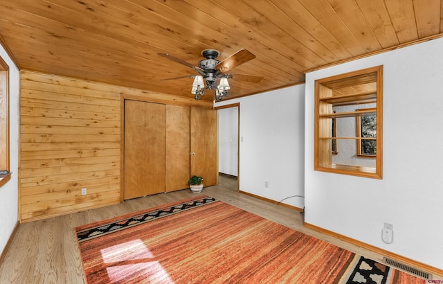 interior space with baseboards, a ceiling fan, visible vents, wood ceiling, and wood finished floors
