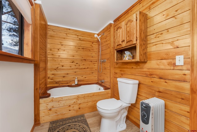 bathroom featuring wood walls, toilet, radiator, and shower / washtub combination