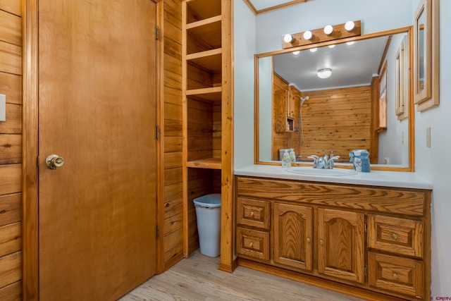 bathroom with crown molding, vanity, and wood finished floors