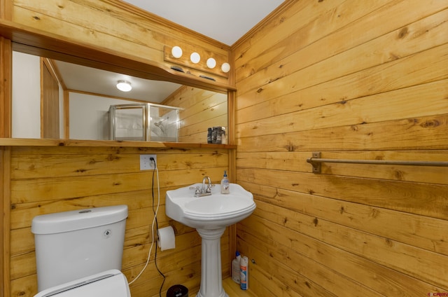 bathroom featuring toilet, a stall shower, and wooden walls