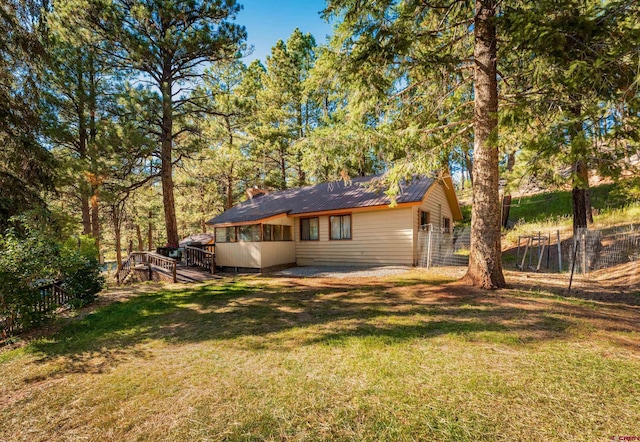 rear view of house with a deck and a lawn