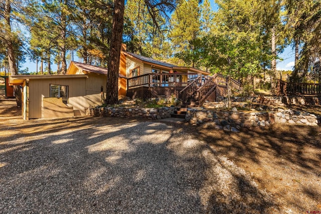 rear view of house featuring a wooden deck and stairway