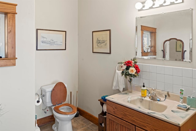 bathroom featuring vanity, toilet, tile patterned floors, and backsplash