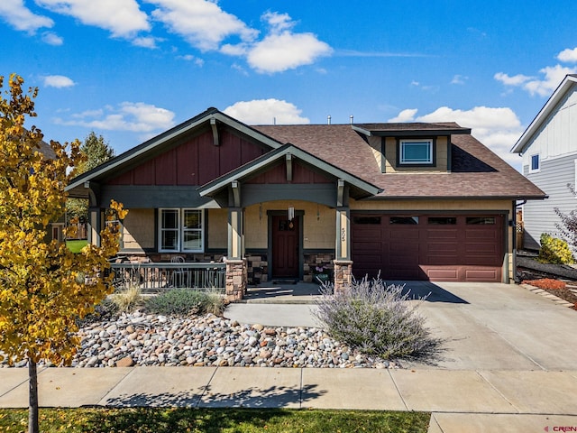 505 Prospector Ave, Durango, CO 81301 - view of front of house featuring a shingled roof, an attached garage, stone siding, covered porch, and driveway