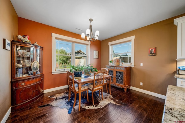 dining space with dark wood-type flooring and a chandelier