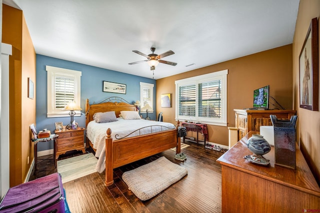 bedroom with multiple windows, ceiling fan, and dark wood-type flooring