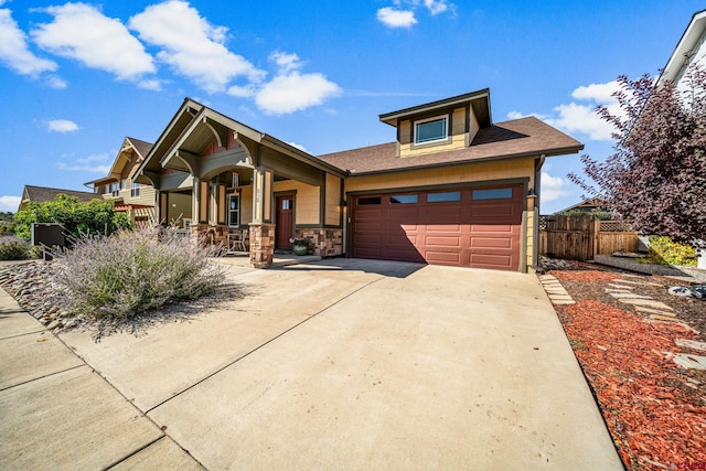 505 Prospector Ave, Durango, CO 81301 - view of front of house featuring an attached garage, a porch, stone siding, fence, and concrete driveway