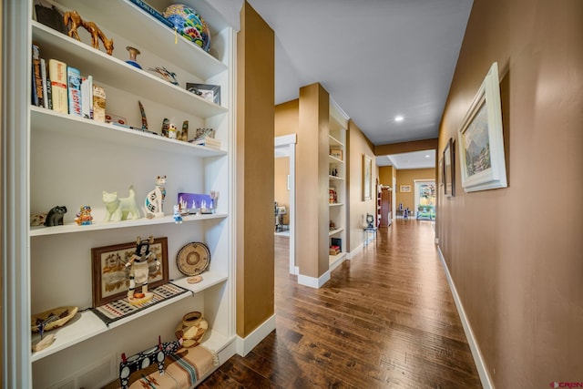 hallway featuring dark wood-type flooring and built in features