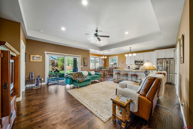 505 Prospector Ave, Durango, CO 81301 - living area featuring dark wood-style flooring, a tray ceiling, and ceiling fan with notable chandelier