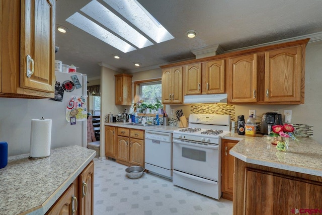 kitchen featuring crown molding, white appliances, sink, and a skylight