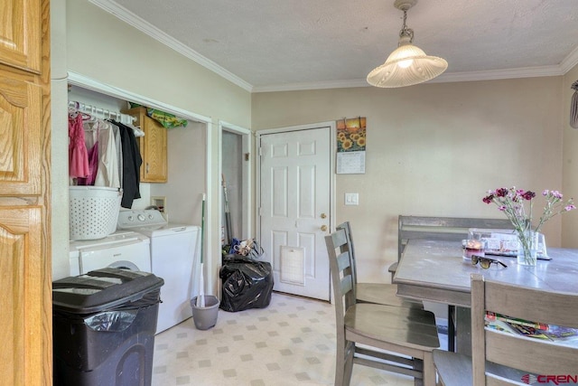 dining room featuring a textured ceiling, washer and clothes dryer, and ornamental molding