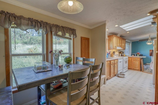 dining area featuring a textured ceiling, ornamental molding, and a skylight