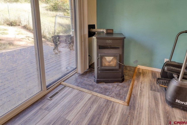 living area featuring wood-type flooring and a wood stove