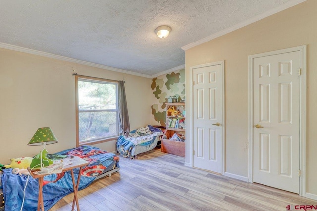 bedroom with a textured ceiling, crown molding, and light hardwood / wood-style flooring