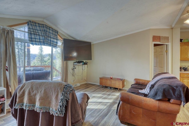 living room featuring wood-type flooring, a textured ceiling, lofted ceiling, and ornamental molding