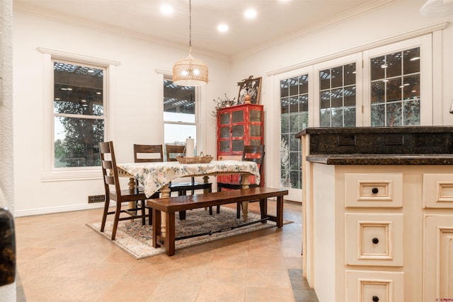 tiled dining room featuring crown molding