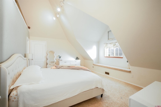 carpeted bedroom featuring vaulted ceiling and track lighting