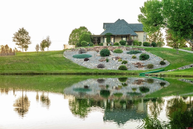 surrounding community featuring a water view and a lawn