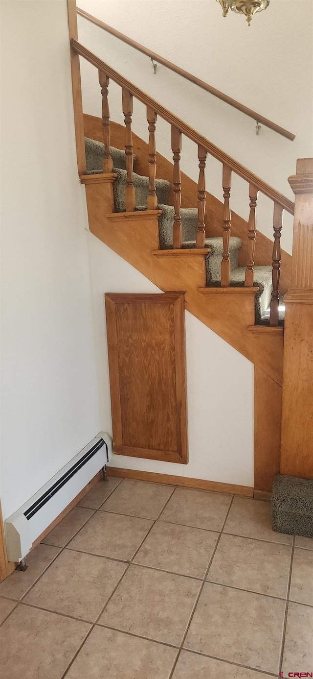 stairs with a baseboard radiator and tile patterned floors