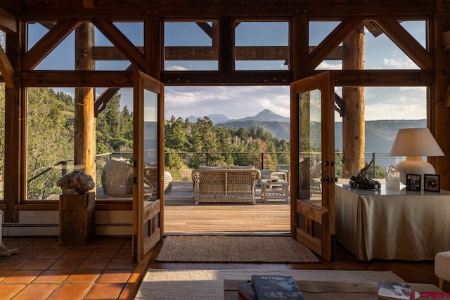 doorway with a mountain view, plenty of natural light, and tile patterned floors