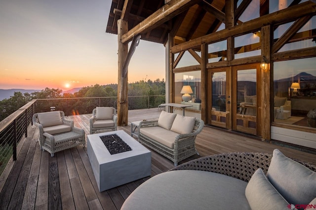 deck at dusk with outdoor lounge area and french doors