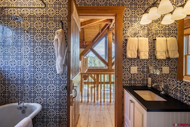 bathroom with a bath, hardwood / wood-style flooring, and vanity