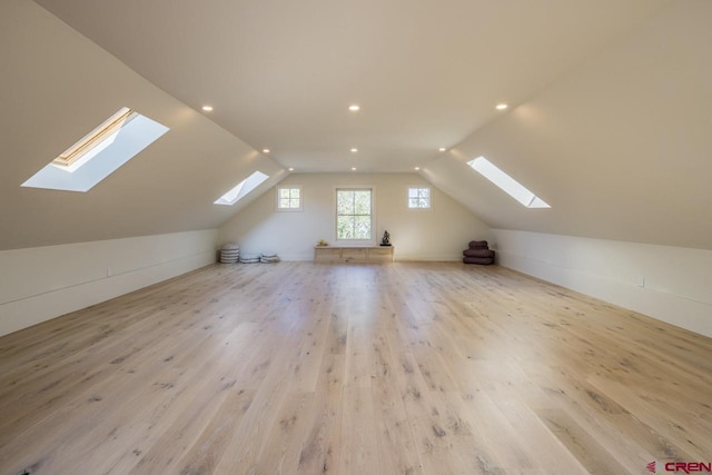 additional living space with light wood-type flooring and vaulted ceiling