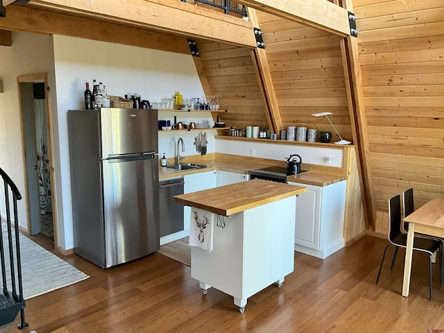 kitchen with wood-type flooring, dishwasher, stainless steel fridge, and wooden counters