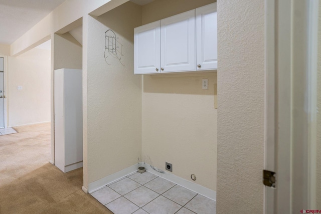 laundry area featuring light colored carpet, cabinets, and electric dryer hookup