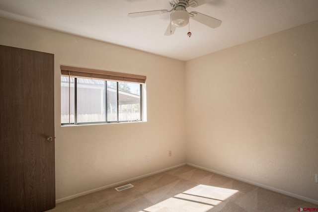 carpeted spare room with ceiling fan