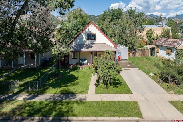 view of front of house featuring a front yard, a mountain view, and a porch