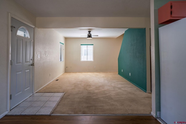 carpeted foyer featuring ceiling fan