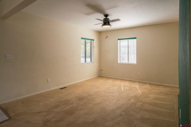 carpeted spare room with ceiling fan