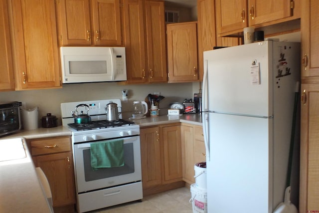 kitchen featuring white appliances, a toaster, visible vents, and light countertops