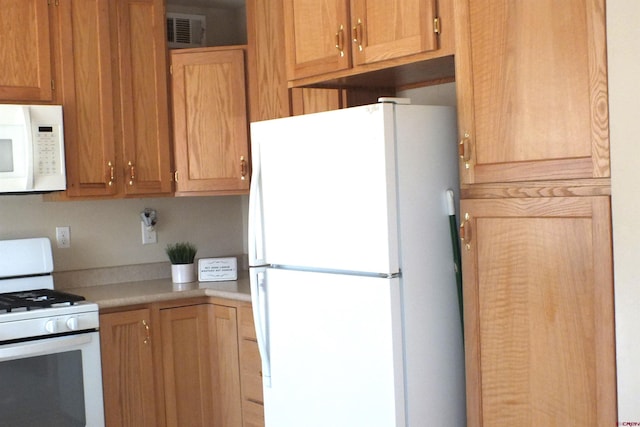 kitchen featuring white appliances, light countertops, and visible vents