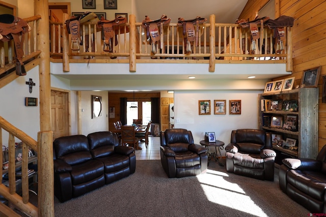 living room with a high ceiling, tile patterned flooring, and wood walls