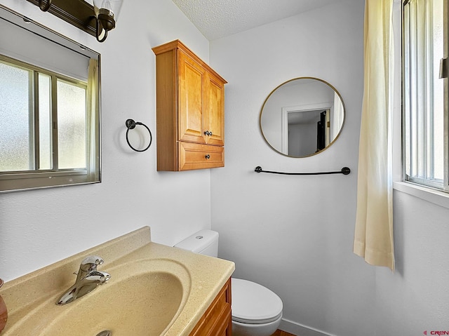 bathroom featuring vanity, a textured ceiling, and toilet